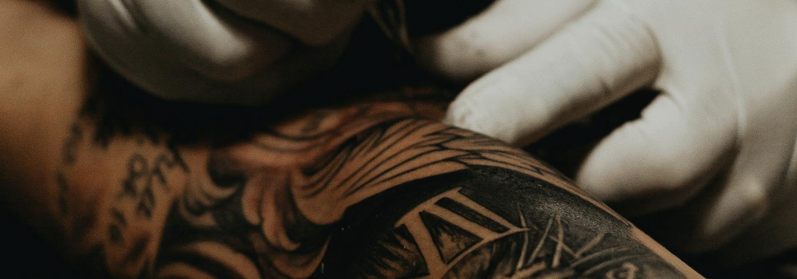 A tattoo artist at work with the machine